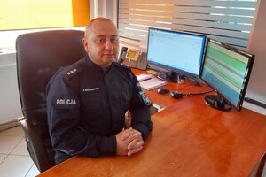 Zdjęcie dyżurnego policji na stanowisku pracy.