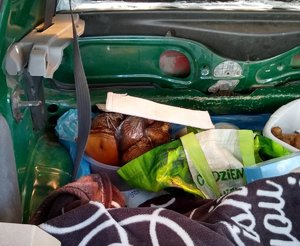 Na zdjęciu widać pakunki z wędliną umieszczone w bagażniku pojazdu
