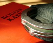 Na zdjęciu widać kodeks karny i kajdanki