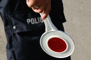 Na zdjęciu widać policjanta trzymającego tarczę do zatrzymywania pojazdów