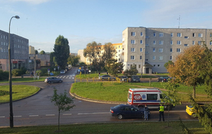 Na zdjęciu widać skrzyżowanie ulic, gdzie doszło do zdarzenia drogowego, 2 pojazdy uszkodzone obok stoi karetka pogotowia