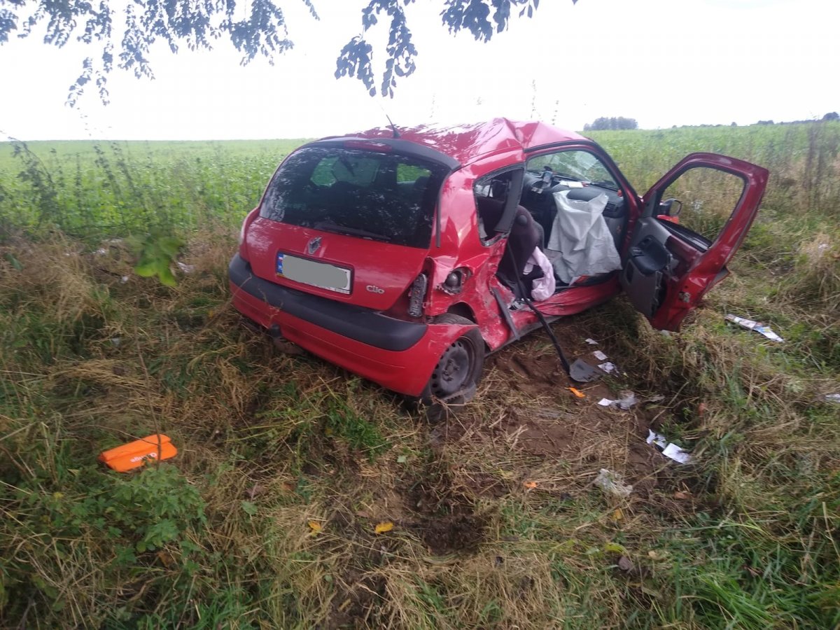 Na zdjęciu widać uszkodzony pojazd w kolorze czerwonym podczas zdarzenia drogowego