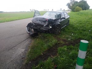 Na zdjęciu widać uszkodzony pojazd w kolorze czarnym podczas zdarzenia drogowego