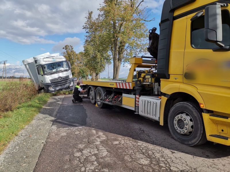 Pojazd holowniczy wyciąga samochód ciężarowy z rowu.