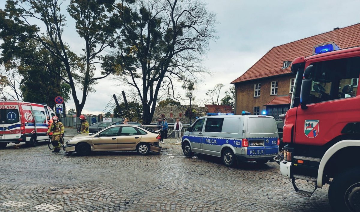 na zdjęciu widać uszkodzony pojazd  obok stoi karetka, wóz strażacki i radiowóz