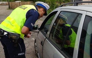 Policjant ruchu drogowego stoi przy pojeździe