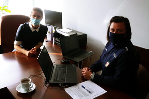 Przy biurku dyrektor siedzą Dyrektor Wydziału Kształcenia, Wychowania i Opieki Kuratorium Oświaty w Olsztynie Małgorzata Hochleitner oraz kom. Ewa Szczepanek z Wydziału Prewencji KWP w Olsztynie