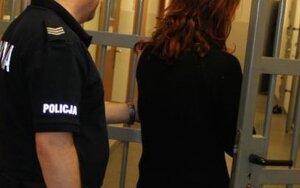 Zatrzymana kobieta prowadzona przez policjanta