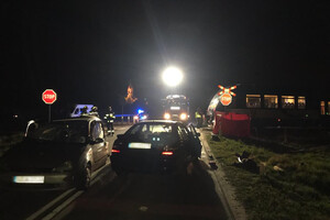 Miejsce zdarzenia drogowego w powiecie ełckim. Rozbite samochody i uszkodzony szynobus oraz funkcjonariusze pracujący na miejscu