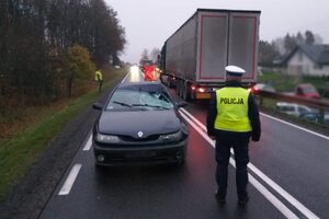 Miejsce zdarzenia drogowego w powiecie mrągowskim trasie Marcinkowo – Bagienice. Po lewej samochód z rozbitą szybą czołową, po prawej ciężarówka i policjant na pierwszym planie