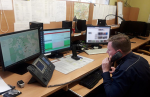 Oficer dyżurny rozmawia przez telefon przy stanowisku pracy