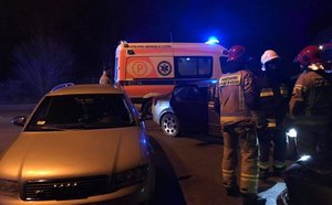 Na zdjęciu służby ratownicze, przy pojeździe Audi stoi 3 strażaków