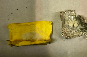 Na zdjęcie żółty woreczek obok leży folia aluminiowa a w niej biały proszek