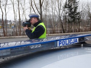 Policjant trzymający urządzenie do mierzenia prędkości