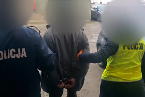 Zatrzymany mężczyzna prowadzony przez policjantów