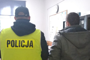 Zatrzymany mężczyzna prowadzony przez policjanta