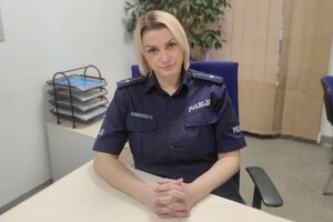 mł. asp. Ewelina Pierzchała w policyjnym mundurze siedząca za biurkiem