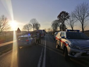 Na zdjęciu dwa pasy w przeciwnym kierunku na którym stoją pojazdy. przy radiowozie stoi dwóch mężczyzn