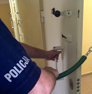 Policjant zamykający drzwi aresztu
