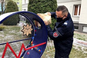 nadinsp. Tomasz Klimek wrzuca plastikowe zakrętki do pojemnika