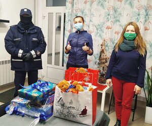 na zdjęciu policjant, 2 panie i zapakowane prezenty