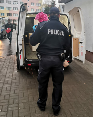 Policjant pakujący do samochody prezenty