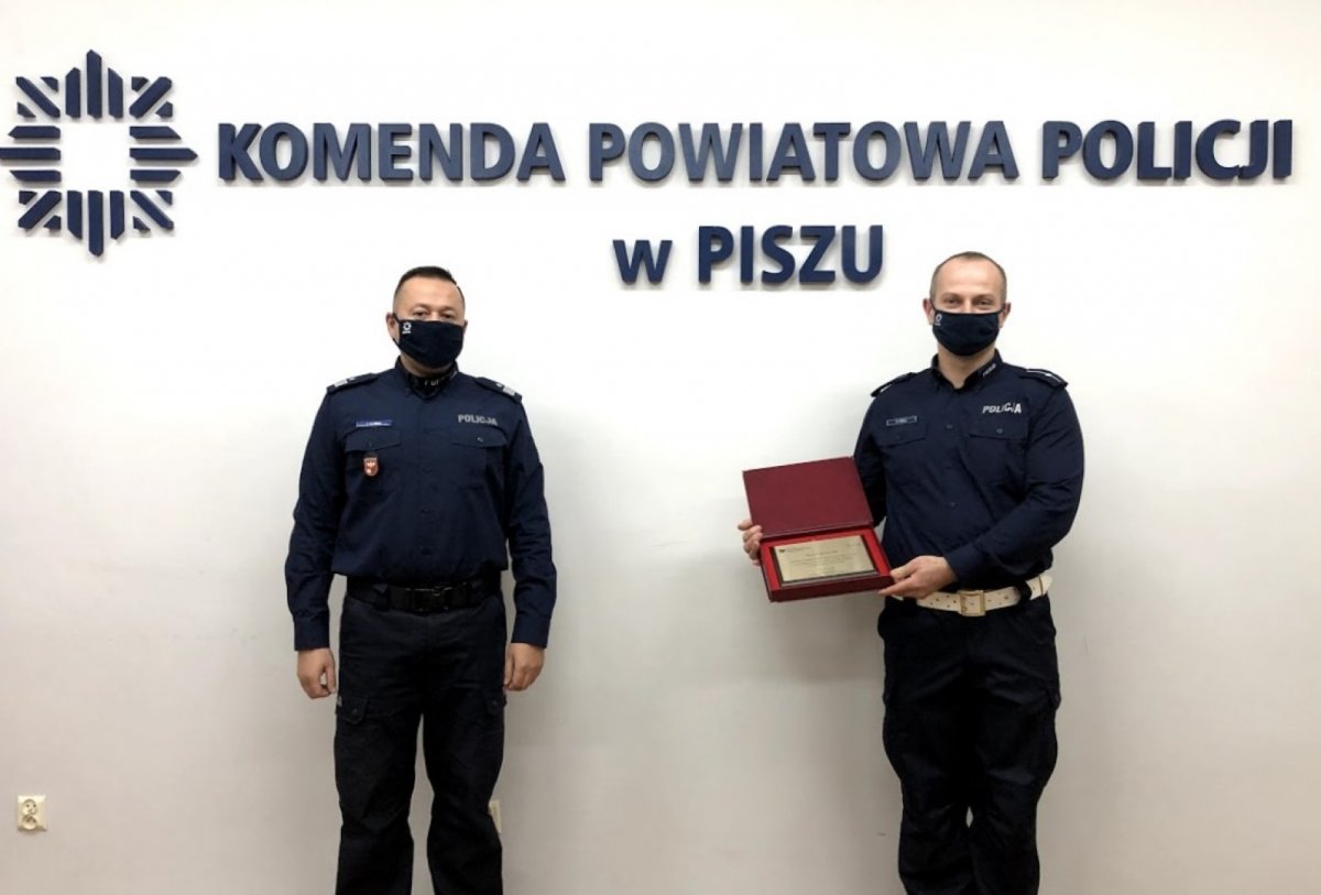 Komendant wręcza wyróżnienie policjantowi z Pisza