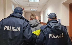 Dwóch policjantów prowadzi mężczyznę