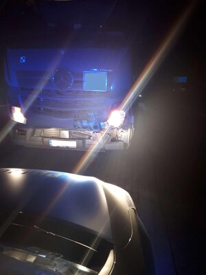 Na zdjęciu przód pojazdu ciężarowego i tył radiowozu