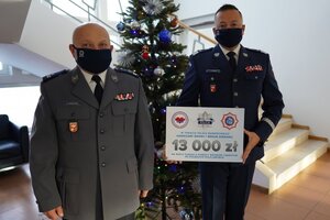 nadinsp. Tomasz Klimek trzyma czek, obok stoi podinsp. Sławomir Koniuszy