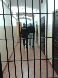 za kratą dwóch mężczyzn stojących tyłem