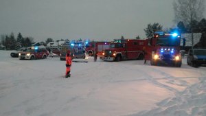 siedem wozów służb ratowniczych, strażacy i ratownik medyczny