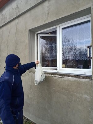 Policjant podający zakupy do okna