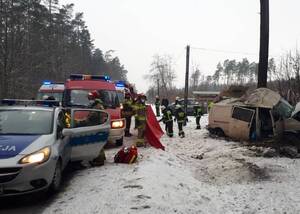 Miejsce zdarzenia drogowego, służby ratunkowe po prawej stronie, po lewej samochód w rowie