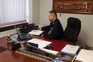 nadinsp. Tomasz Klimek za biurkiem podczas odprawy