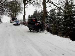 po prawej stronie wzdłuż drogi radiowóz i straż pożarna przed pojazdami bokiem samochód w rowie