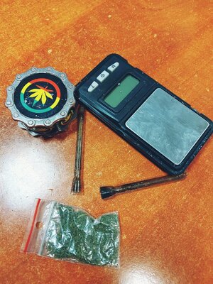 Na zdjęciu mała waga, 2 fifki, woreczek strunowy z zawartością zielonego suszu