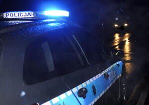 Radiowóz na sygnałach świetlnych wieczorową porą