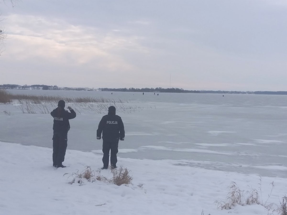 Policjanci obserwujący zamarznięte jezioro