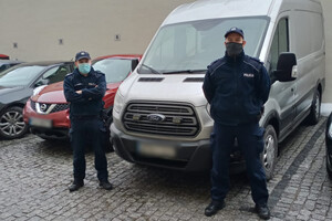 sierż. szt. Dawid Słowy i st. sierż. Maciej Głogowski przy radiowozie nieoznakowanym