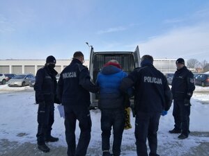 policjanci w trakcie konwoju osoby do zakładu karnego