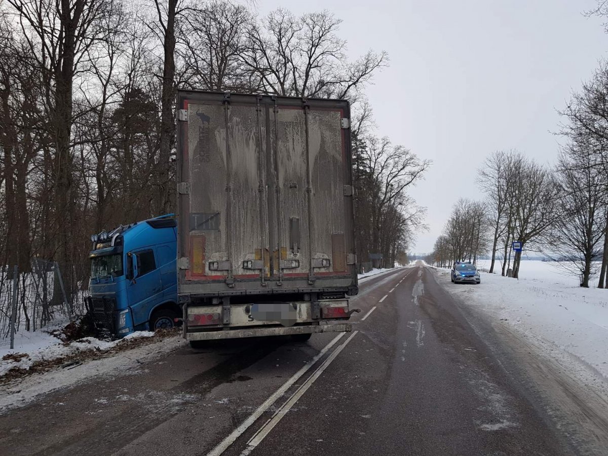 Po lewej stronie drogi samochód ciężarowy w rowie, po prawej na poboczu stoi radiowóz