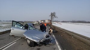 na drodze rozbite auto osobowe, dalej służby ratownicze i samochód ciężarowy