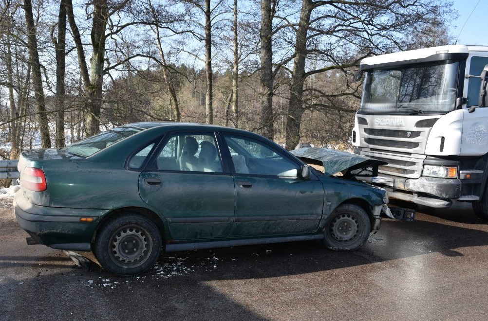 Pojazd osobowy z przodem rozbitym stoi przed pojazdem ciężarowym