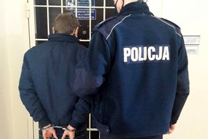 Zatrzymany mężczyzna prowadzony przez policjanta