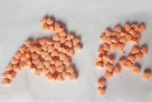 Zabezpieczone narkotyki, tabletki w kształcie serca rozsypane na stole