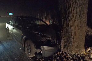Rozbity samochód stojący przy drzewie, w które wcześniej uderzył