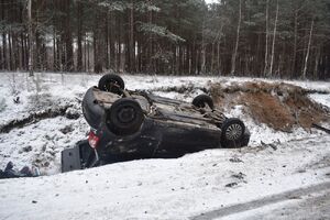 samochód osobowy leżący w rowie kołami do góry