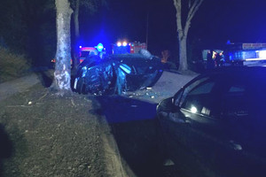 Samochód osobowy, który uderzył w drzewo, wokół służby ratownicze