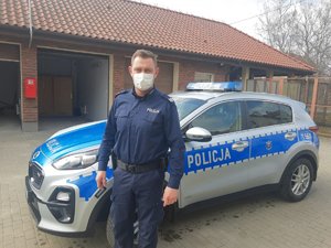 policjant stojący przy radiowozie